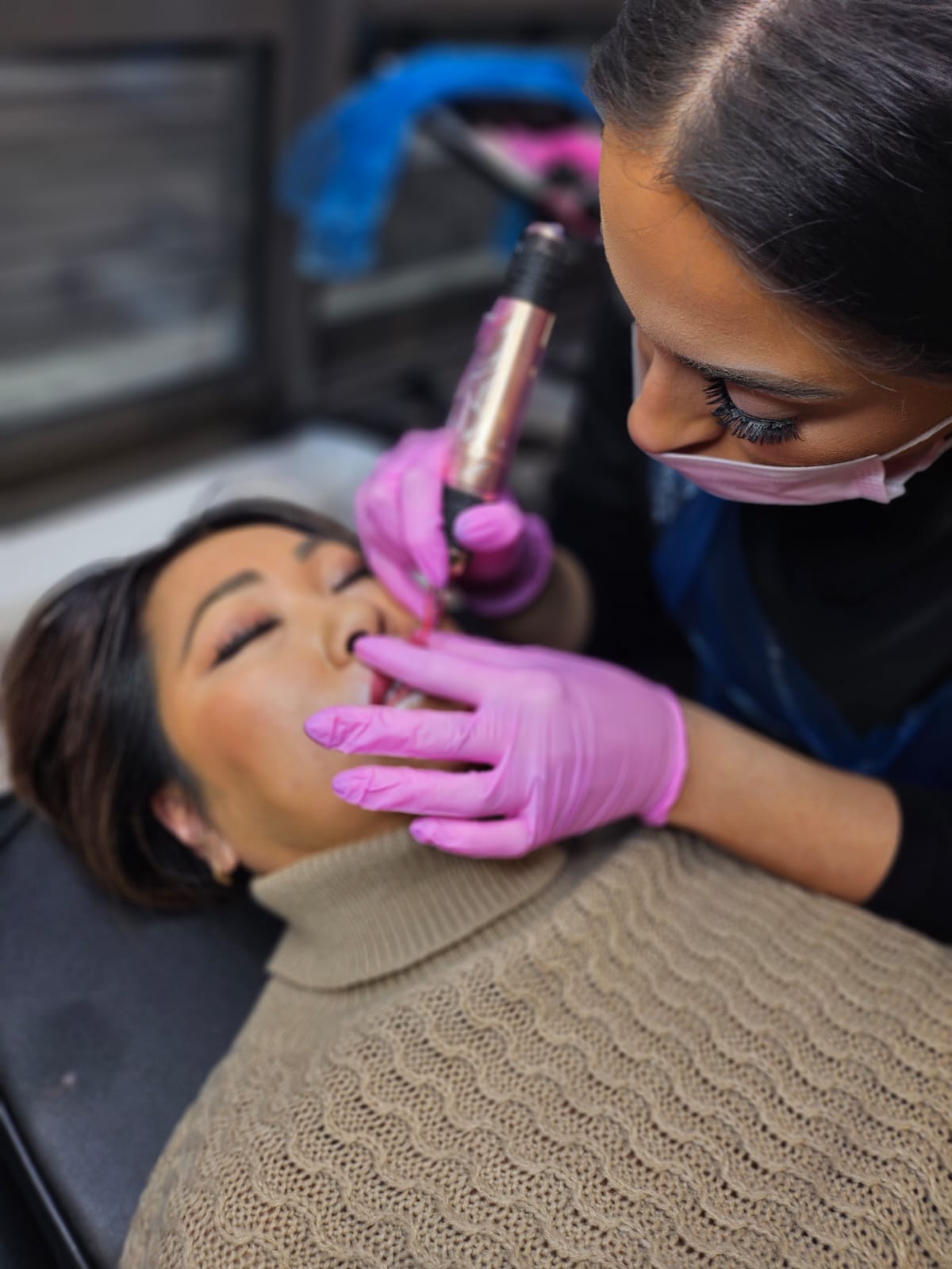 Artist performing lip blush on a client during a training day